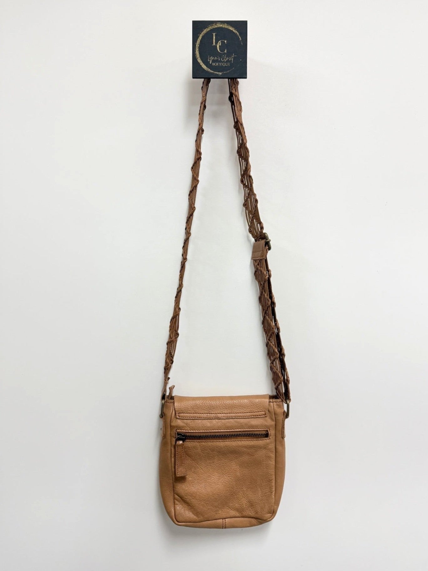Lynn's Closet Boutique brown leather crossbody bag with a unique braided strap and exterior zippered pocket.