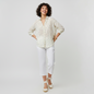 Model wearing Lynn's Closet Boutique Catherine Gee cream long-sleeve blouse with origami crane print and white pants