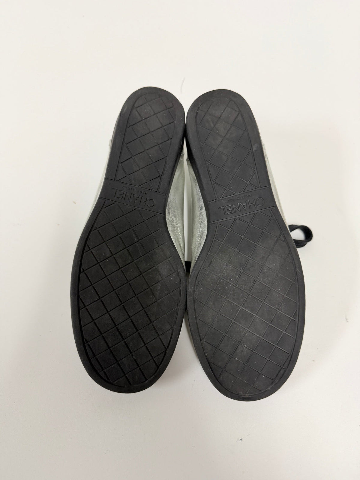 Lynn's Closet Boutique Chanel sneakers showing the black rubber soles with embossed CC logo and diamond pattern