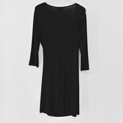 Lynn's Closet Boutique Chicos Travelers black faux wrap dress with three-quarter sleeves hanging against a white wall.
