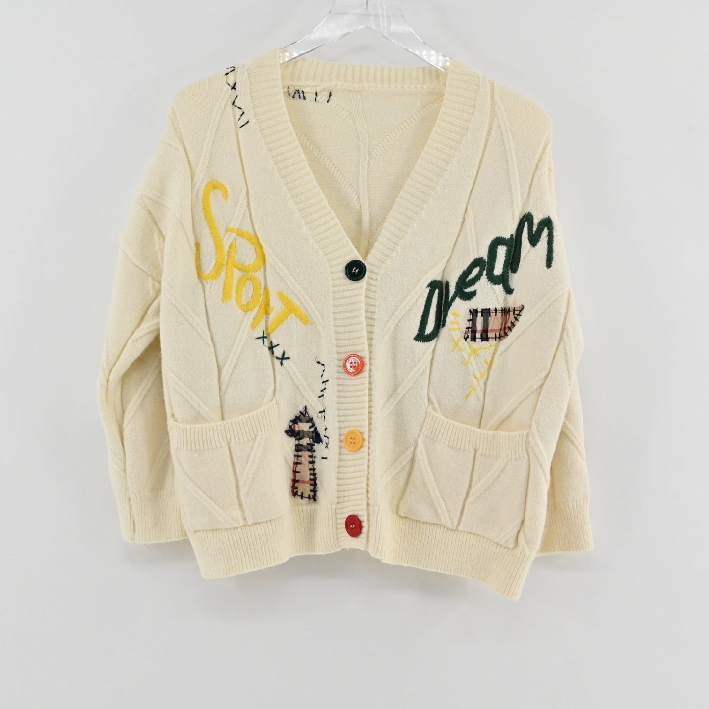 Lynn's Closet Boutique cream cable knit cardigan featuring colorful patchwork, embroidered lettering, and button front.