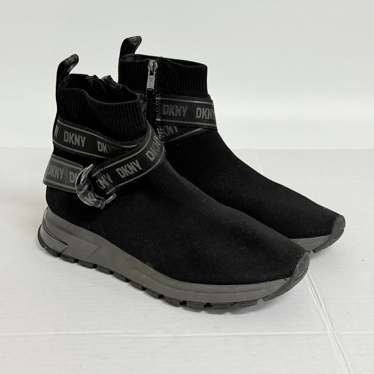 Lynn's Closet Boutique DKNY Miley black knit high-top sneakers with logo strap, side zip, and lugged rubber sole.
