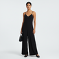 Model wearing an Eileen Fisher black V-neck jumpsuit with spaghetti straps from Lynn's Closet Boutique