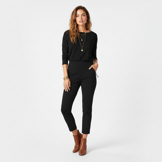 Model wearing Lynn's Closet Boutique Eileen Fisher black high-waist slim-fit pants with a long-sleeve top and boots.