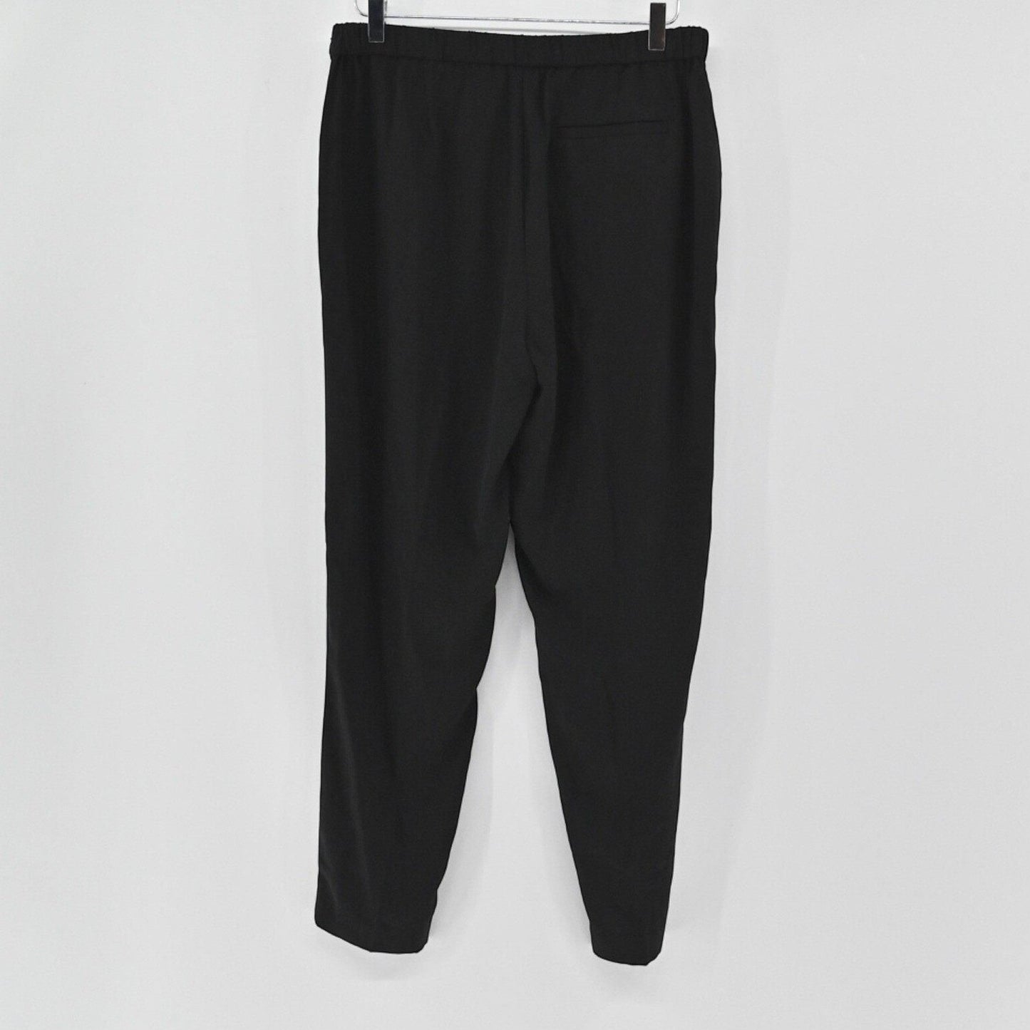 Lynn's Closet Boutique Eileen Fisher black tapered ankle pants with a clean waistband and back pocket hanging on a rack