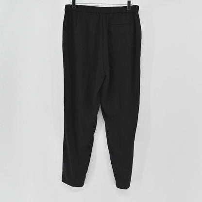 Lynn's Closet Boutique Eileen Fisher black tapered ankle pants with a clean waistband and back pocket hanging on a rack