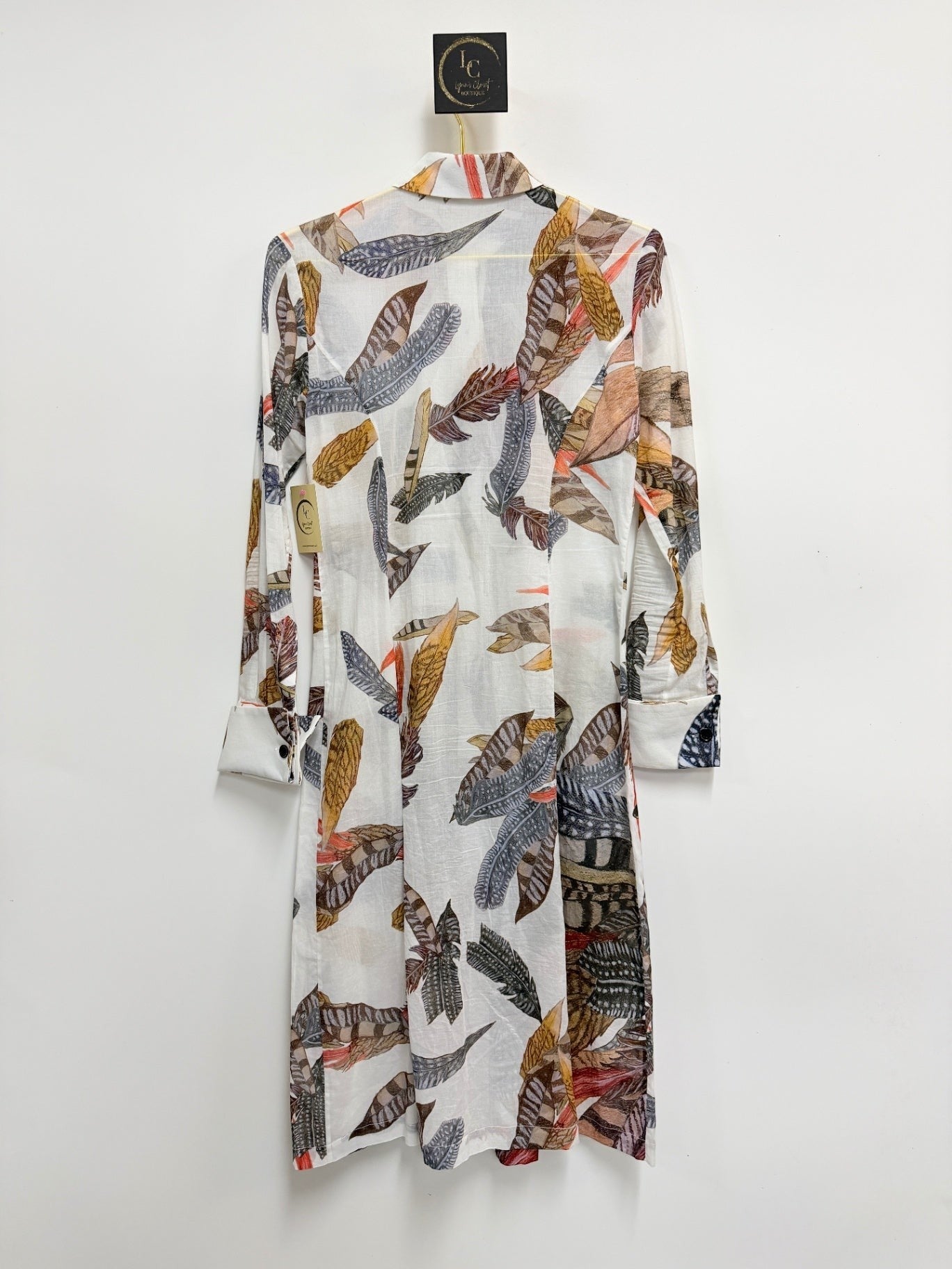 Lynn's Closet Boutique Ala von Auersperg midi shirt dress in white with a multi-colored feather print pattern.