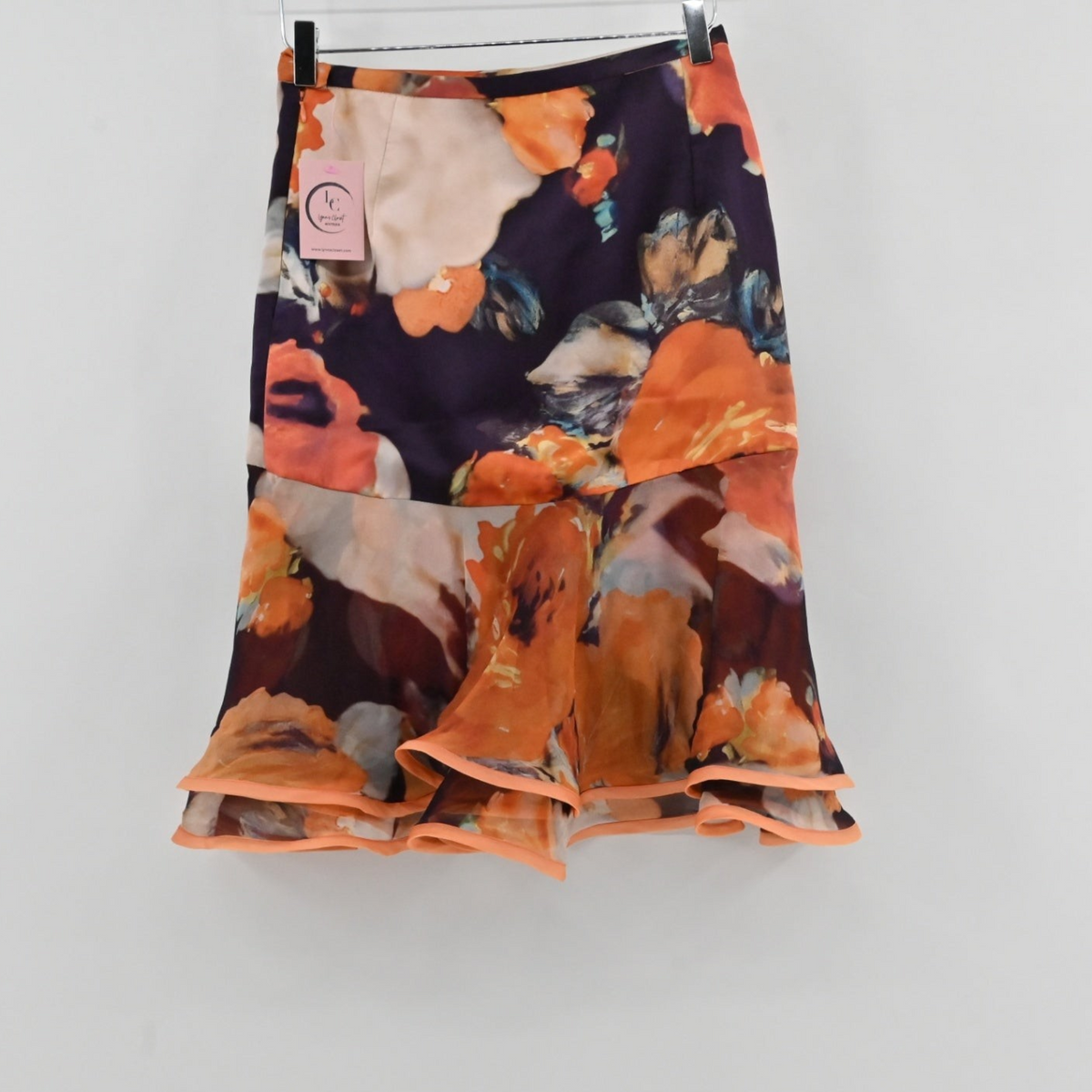 Lynn's Closet Boutique Manzoni Couture floral skirt with a dark base, orange and cream flowers, and a tiered ruffle hem