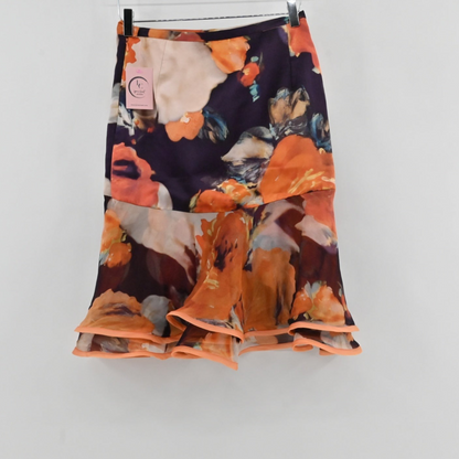 Lynn's Closet Boutique Manzoni Couture floral skirt with a dark base, orange and cream flowers, and a tiered ruffle hem