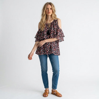 Model wearing a Lynn's Closet Boutique Kate Spade floral silk cold-shoulder top with ruffled sleeves and blue jeans.