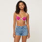 Model wearing a Lynn's Closet Boutique L Space fuchsia bikini top with white trim and denim shorts