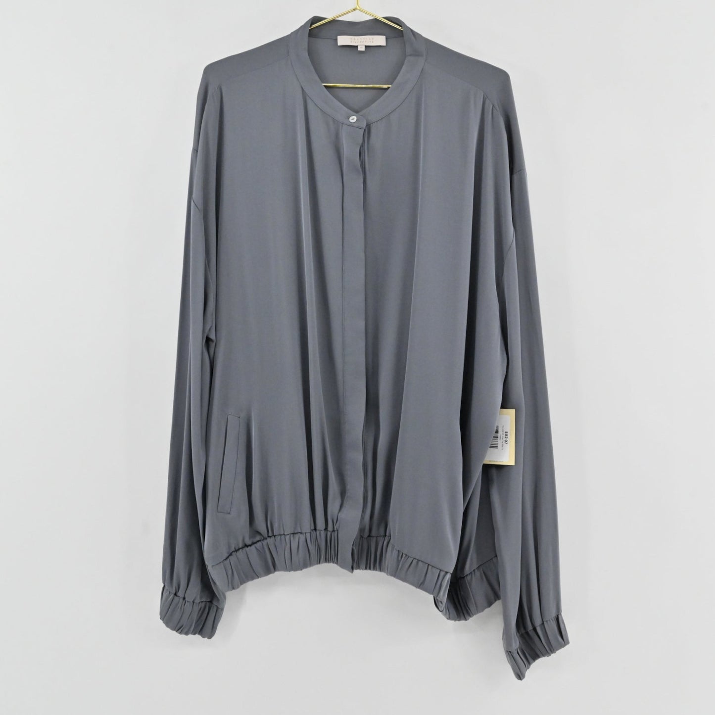 Lynn's Closet Boutique Nouvelle slate gray silk-feel blouse with a collarless button-front and elasticized hem.