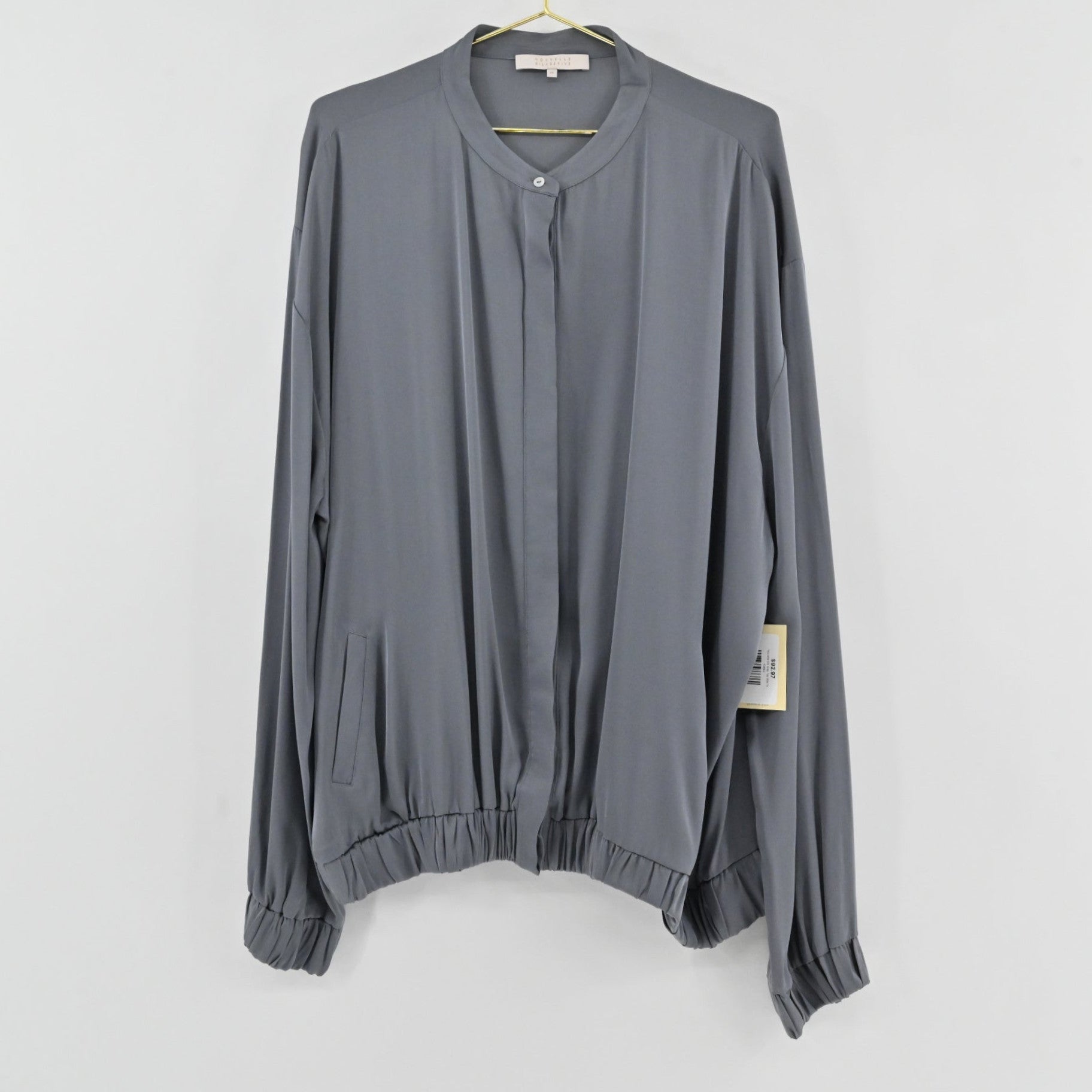 Lynn's Closet Boutique Nouvelle slate gray silk-feel blouse with a collarless button-front and elasticized hem.