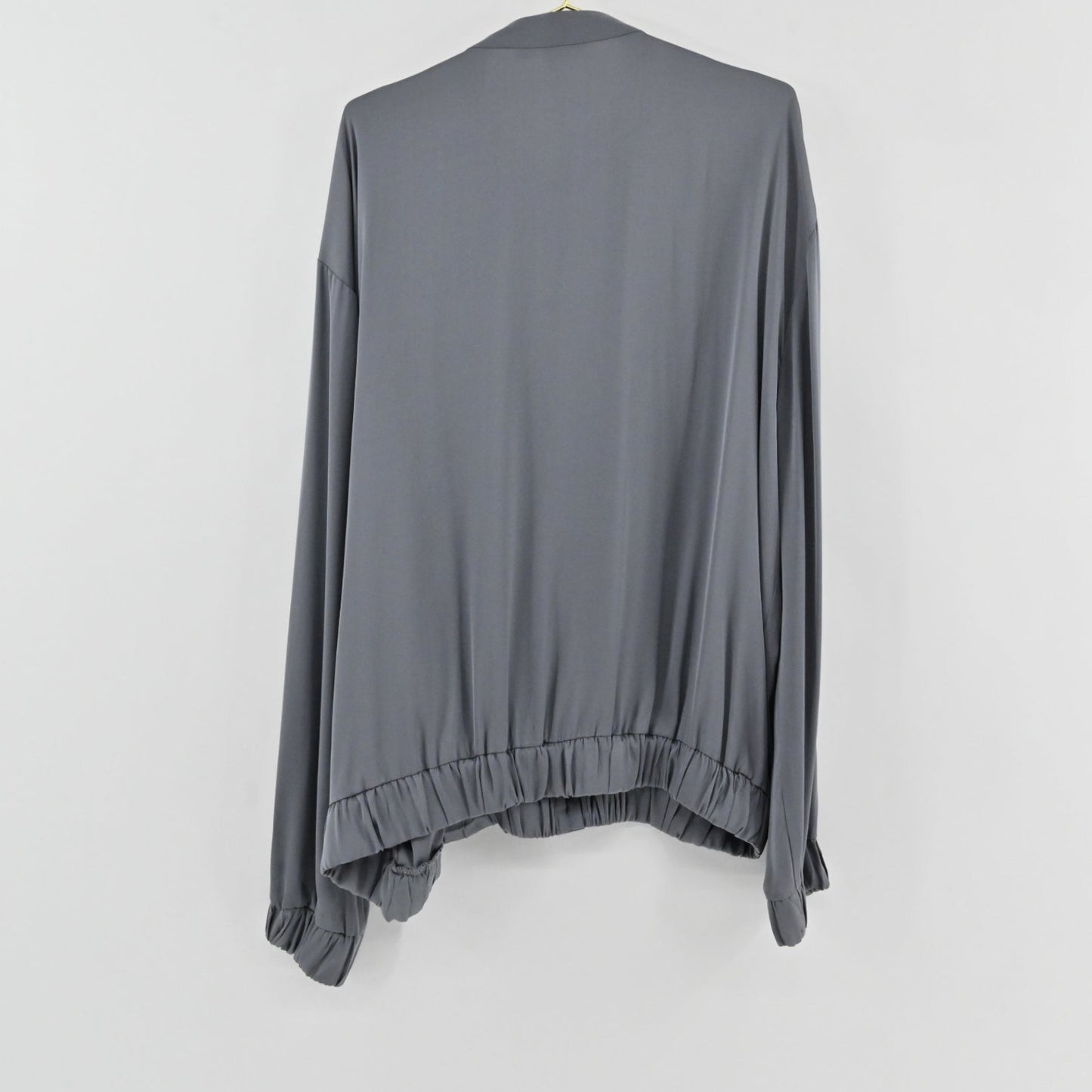Lynn's Closet Boutique slate gray silk-feel top with a relaxed fit, elasticized hem, and cuffed sleeves, back view.