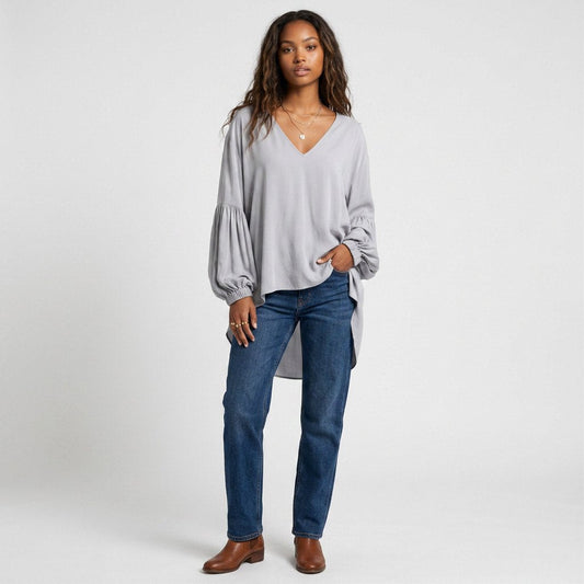 Lynn's Closet Boutique greige silk blouse with balloon sleeves and V-neck worn by a model with dark wash jeans