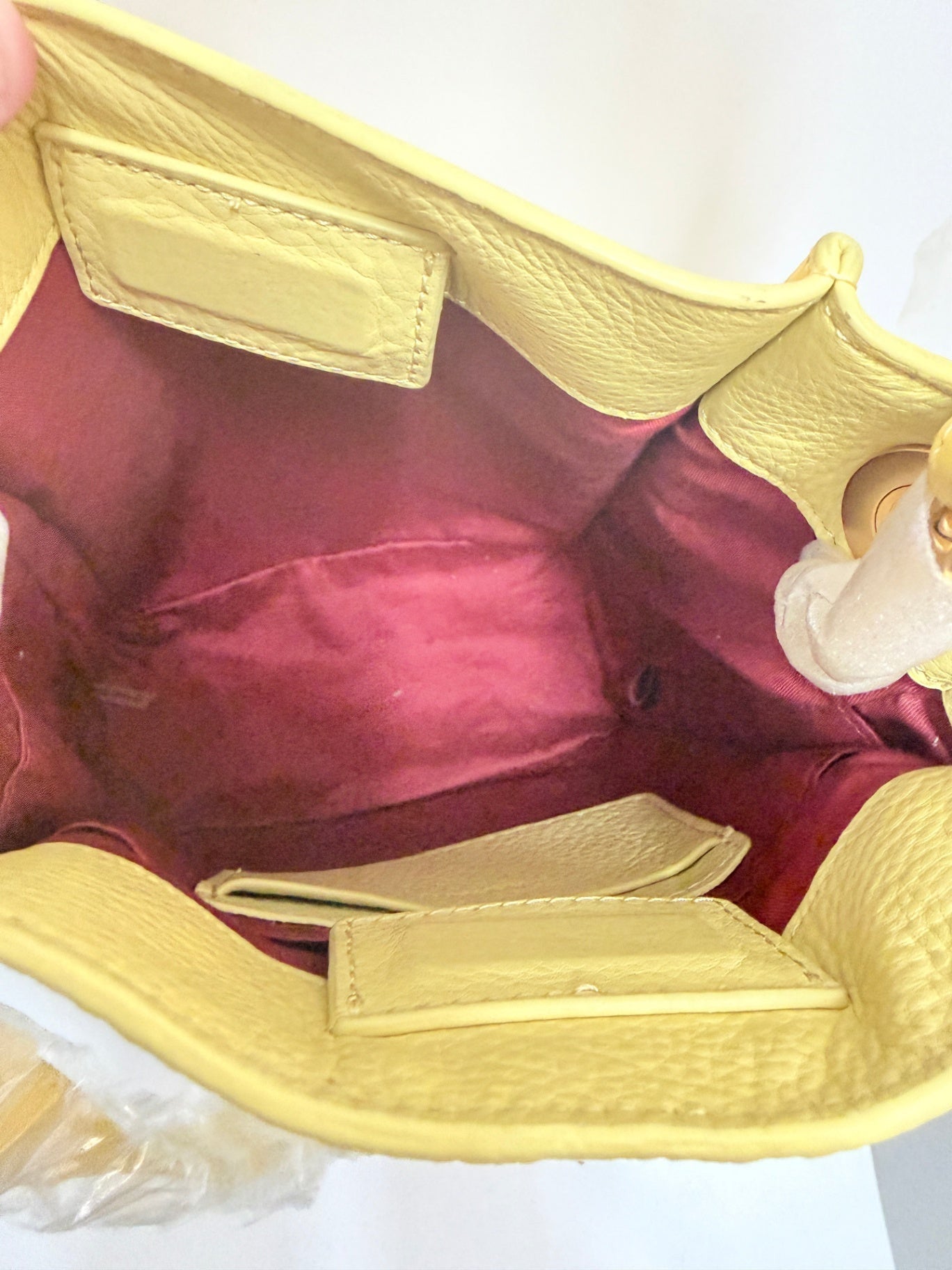 Interior view of Lynn's Closet Boutique Hammitt yellow leather crossbody bag with a deep red fabric lining.