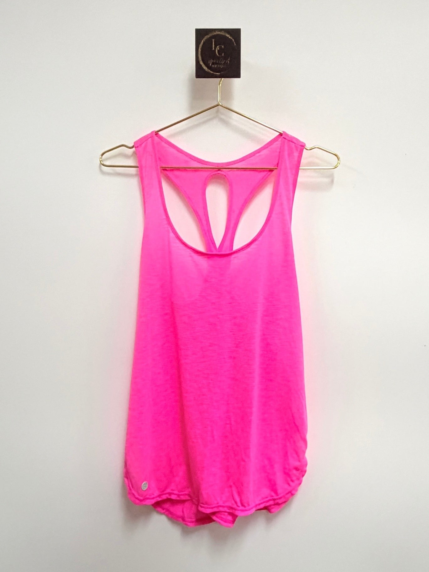Lynn's Closet Boutique hot pink Lilly Pulitzer Luxletic racerback tank top with cutout detail on a gold hanger.