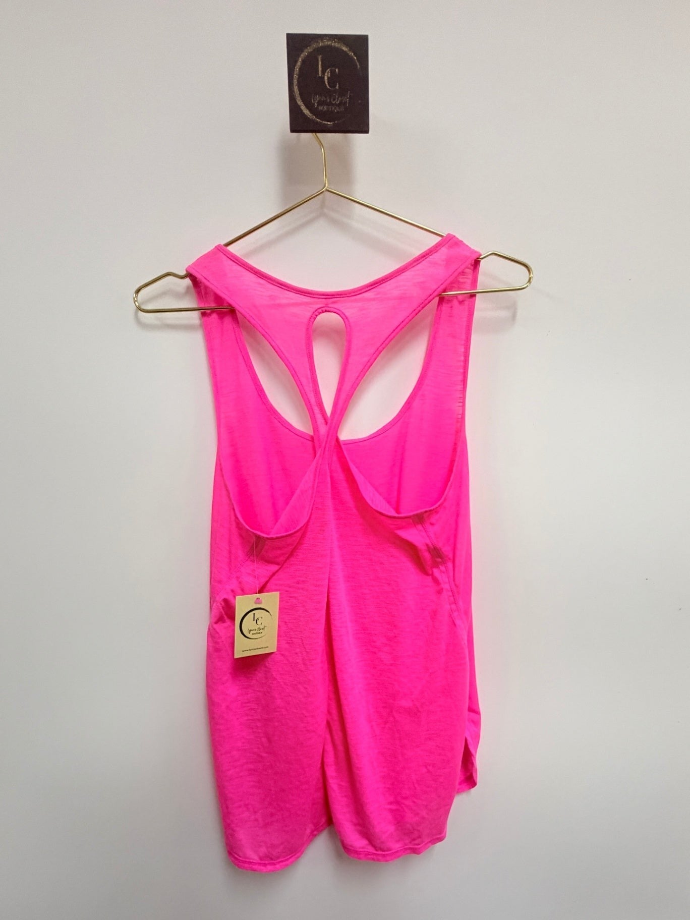 Lynn's Closet Boutique hot pink Lilly Pulitzer Luxletic racerback tank top with cutout detail on a hanger