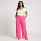Model wearing Lynn's Closet Boutique L'AGENCE hot pink high-rise wide-leg trousers with a white top and nude heels