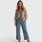 Lynn's Closet Boutique Hudson blue snakeskin print straight-leg jeans with raw frayed hem and side slits on a model