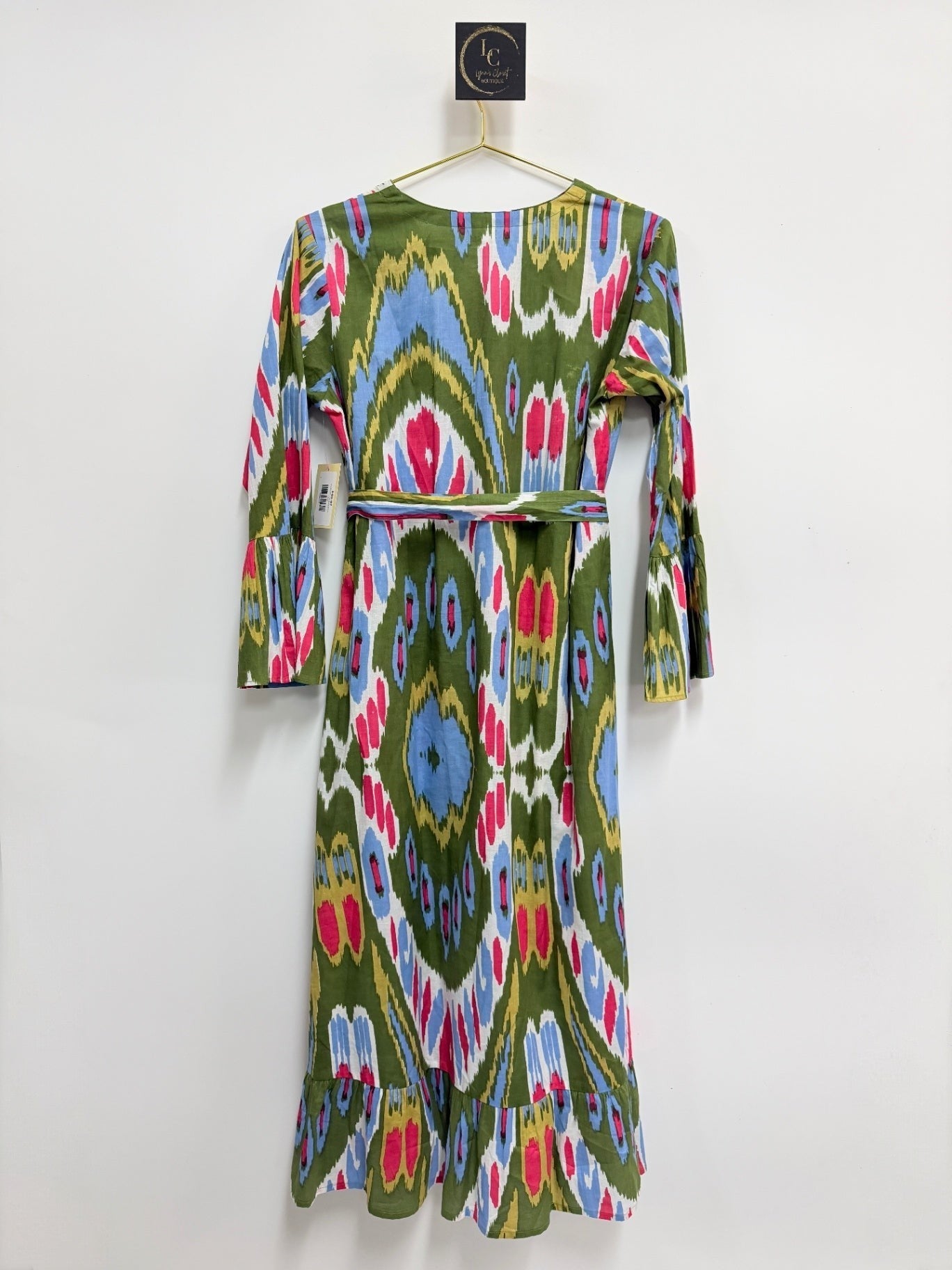 Lynn's Closet Boutique midi dress in olive green with a vibrant multi-colored ikat print, bell sleeves, and ruffle hem.