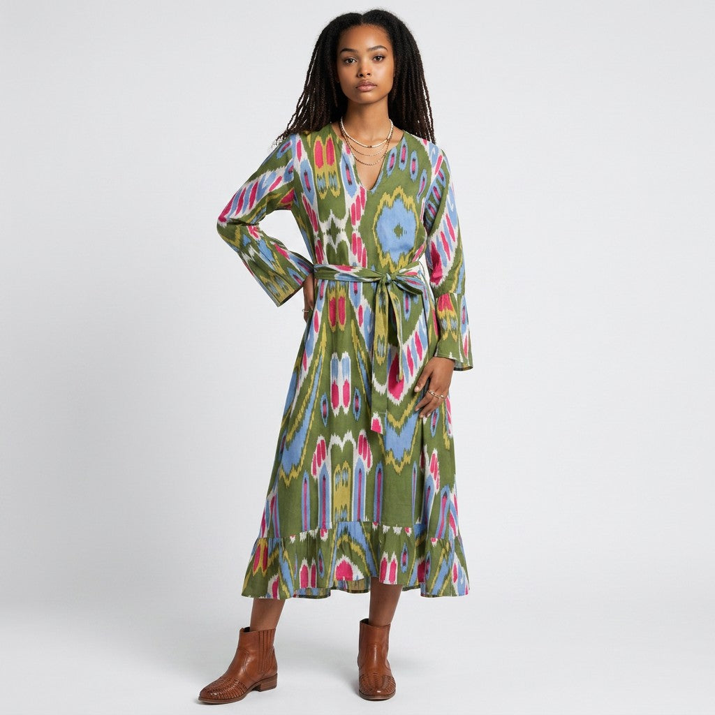 Model wearing a Lynn's Closet Boutique Farylina midi dress with a green ikat print, v-neck, and tie waist.