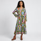 Model wearing a Lynn's Closet Boutique Farylina midi dress with a green ikat print, v-neck, and tie waist.