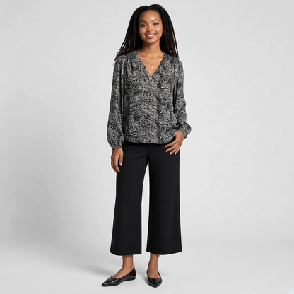 Model wearing a Lynn's Closet Boutique Joie black and white animal print silk V-neck blouse with long sleeves.