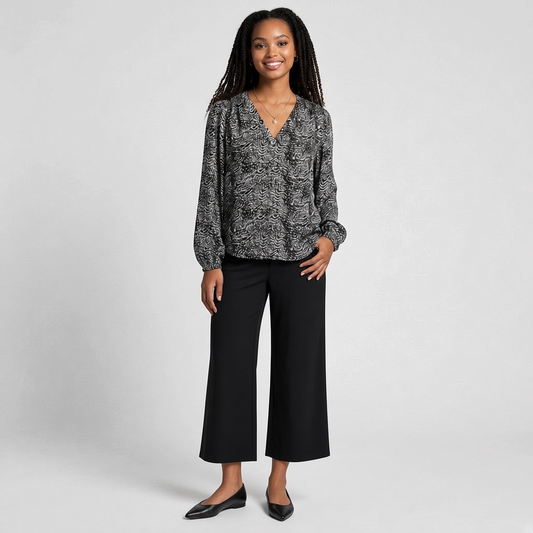 Model wearing a Lynn's Closet Boutique Joie black and white animal print silk V-neck blouse with long sleeves.