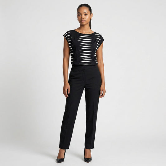 Model wearing a Lynn's Closet Boutique Josie Natori black and white graphic print cap sleeve top with black trousers.