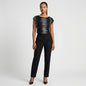 Model wearing a Lynn's Closet Boutique Josie Natori black and white graphic print cap sleeve top with black trousers.