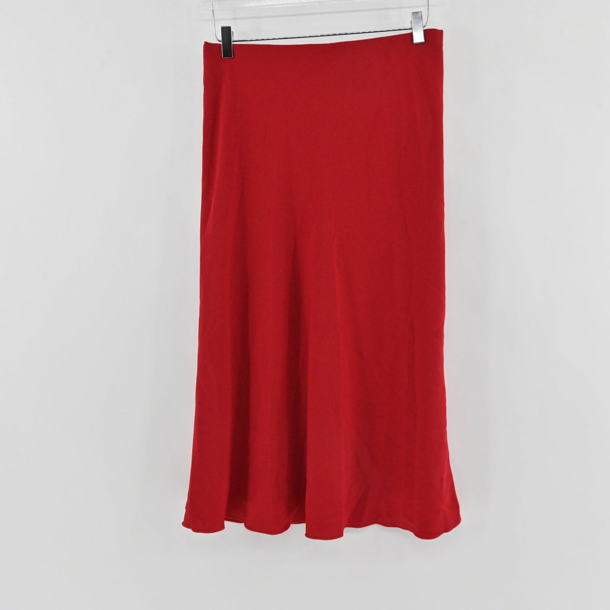 Lynn's Closet Boutique Karen Kane red bias-cut midi skirt hanging on a hanger against a white background