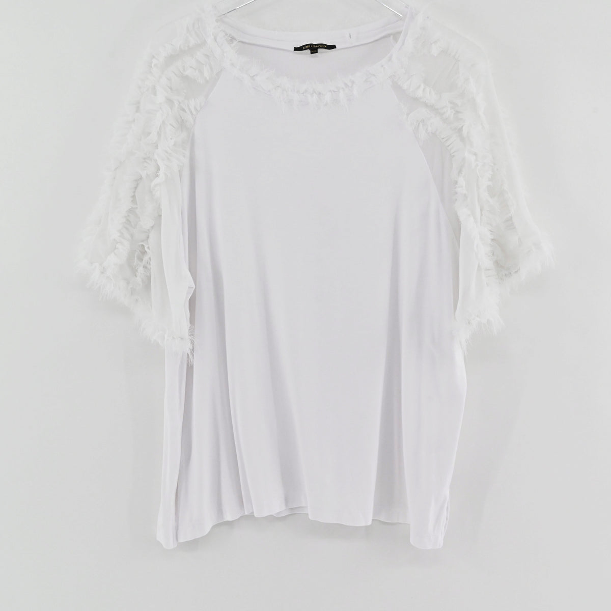 Lynn's Closet Boutique white Kobi Halperin Betsy top with textured ruffle sleeves and neckline on a hanger