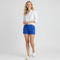 Model wearing Lynn's Closet Boutique Lilly Pulitzer blue wavy textured Callahan shorts with a white linen shirt