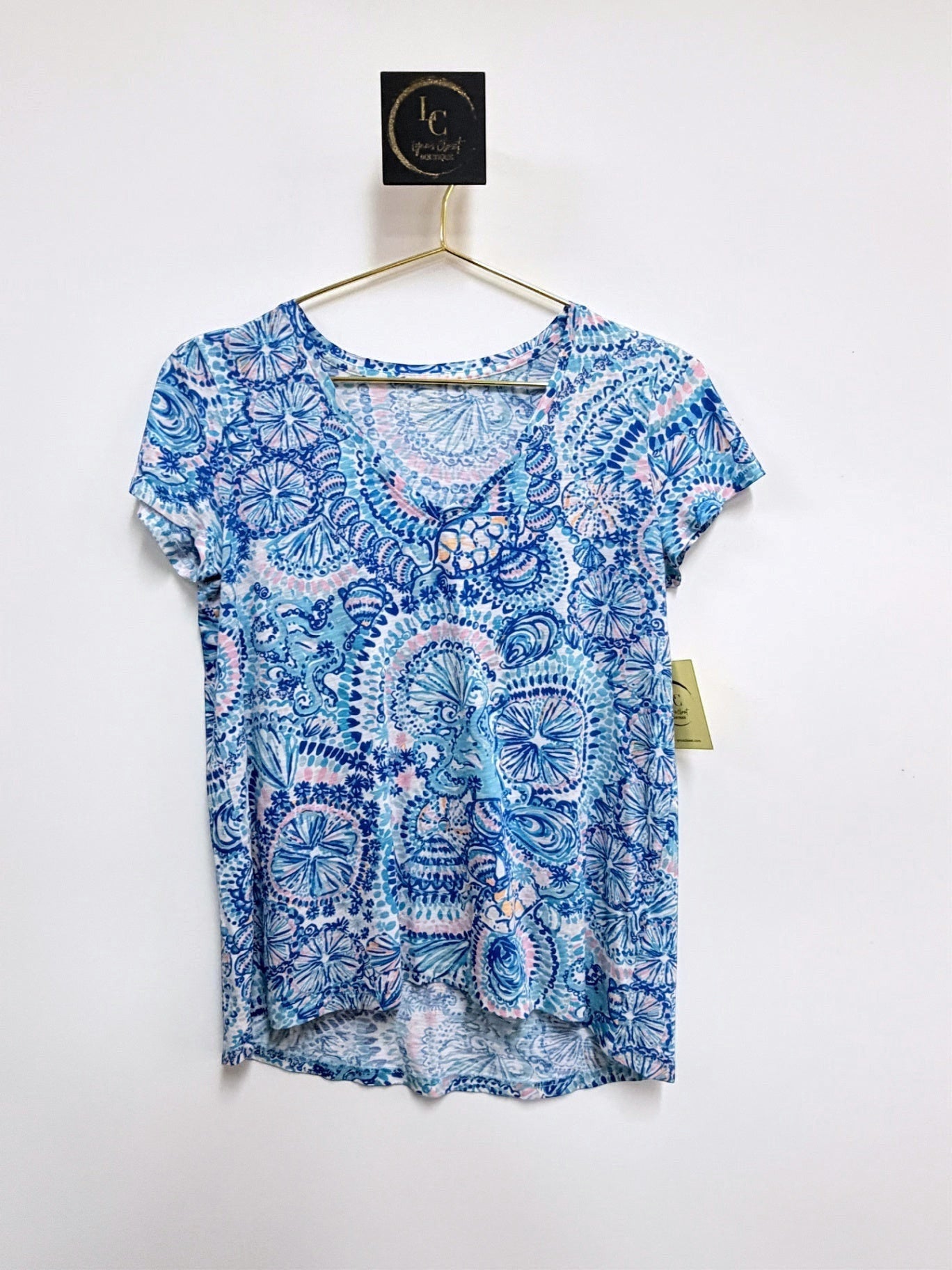 Lynn's Closet Boutique Lilly Pulitzer Etta V-neck tee in a blue and pink kaleidoscope print on a hanger