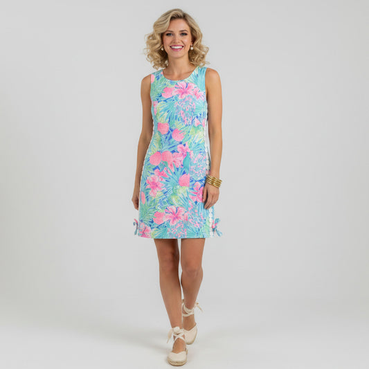 Lynn's Closet Boutique sleeveless Lilly Pulitzer Mila dress in size 4, featuring a vibrant tropical print with pink hibiscus flowers, oranges, and green palm leaves, accented with white pom-pom trim.