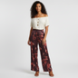 Model wearing Lynn's Closet Boutique Misook floral straight-leg satin crepe pants in burgundy with red floral print.