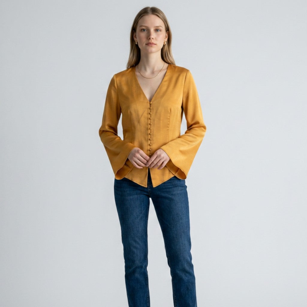 Model wearing a mustard yellow Joie Madora bell sleeve top with button-front detail from Lynn's Closet Boutique