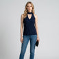 Model wearing a Lynn's Closet Boutique navy sleeveless knit top with a cutout neckline and high collar with jeans.
