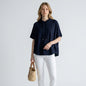 Lynn's Closet Boutique Joie navy blue merino wool short-sleeve hoodie worn by a model with white jeans and sandals
