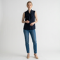 Model wearing a Lynn's Closet Boutique navy sleeveless Tory Burch top with a tie-neck bow and blue jeans.