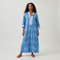 Model wearing a blue NicoBlu kaftan dress with coral print and white trim from Lynn's Closet Boutique
