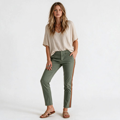 Model wearing Lynn's Closet Boutique olive green Nili Lotan trousers with a side stripe and raw-edge hem.
