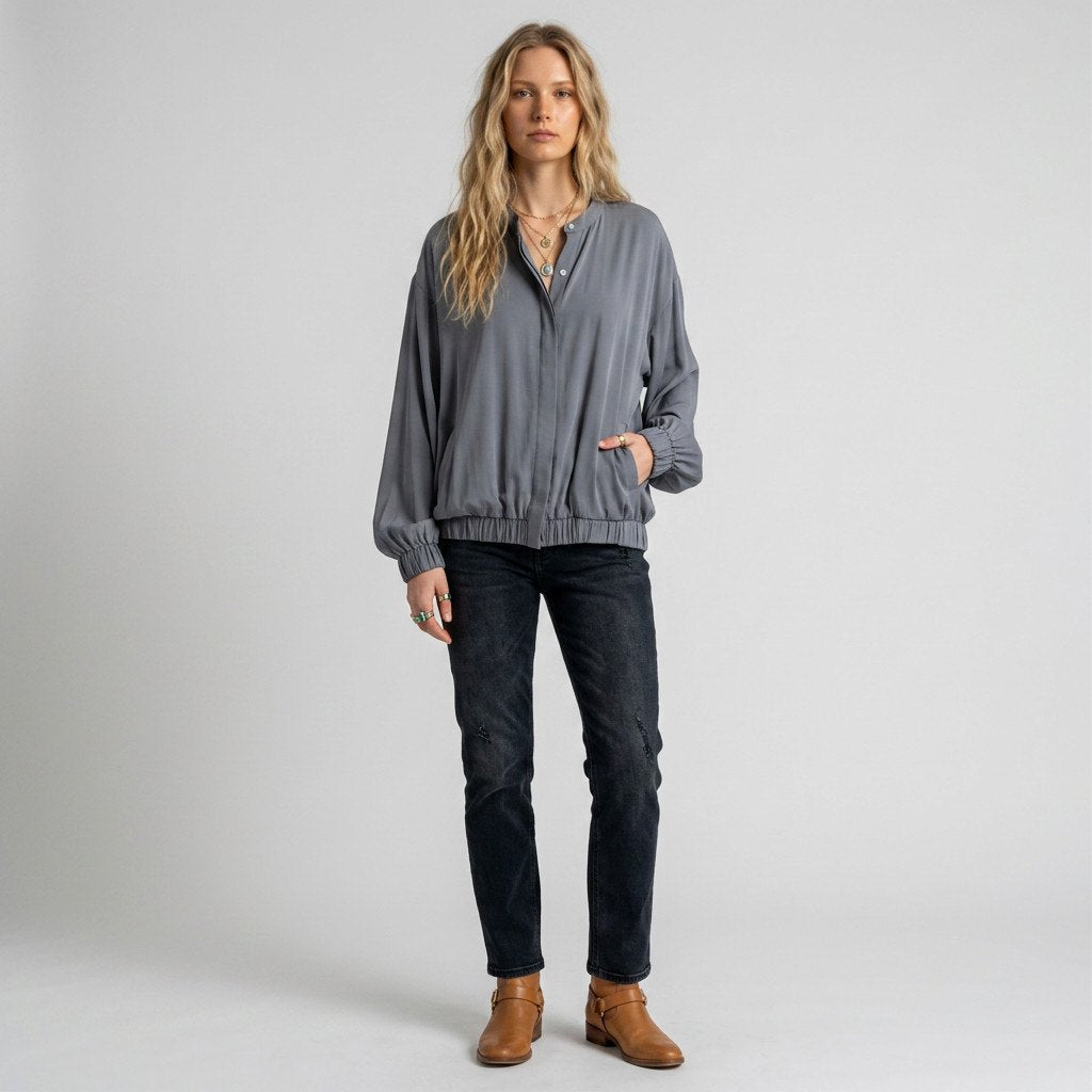 Lynn's Closet Boutique Nouvelle silk gray top with button-front, elastic hem, and side pockets worn by a model.
