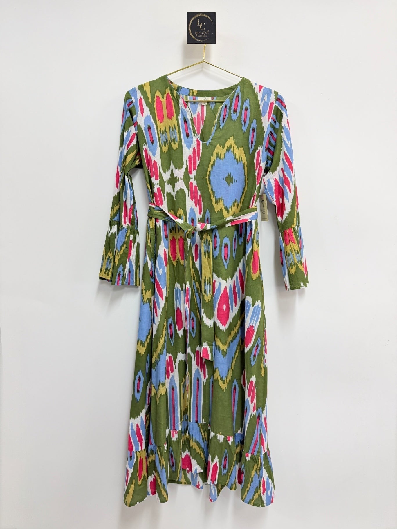 Lynn's Closet Boutique olive green midi dress with a vibrant multi-colored ikat print, V-neck, and bell sleeves.