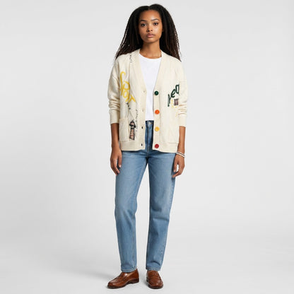 Model wearing a Lynn's Closet Boutique cream patchwork cable knit cardigan with colorful buttons and graphic details.