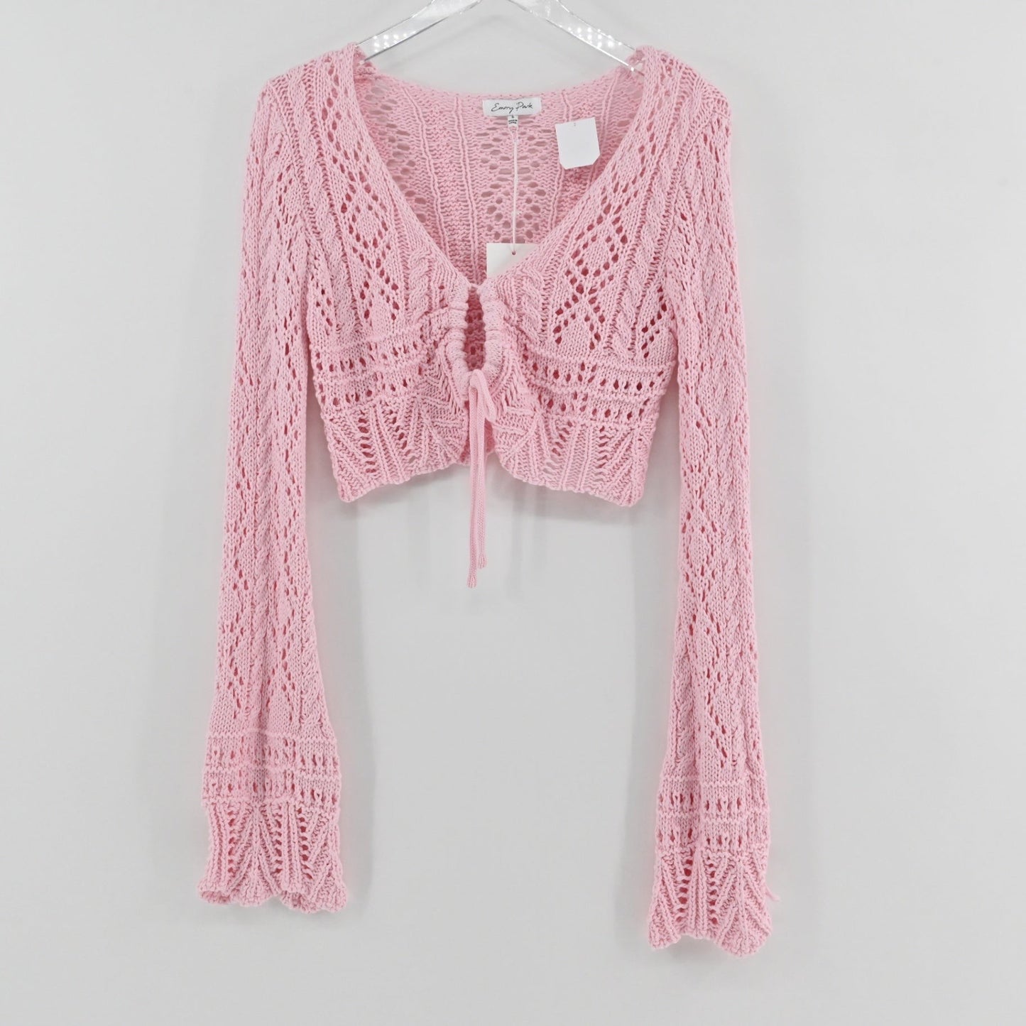 Lynn's Closet Boutique Emory Park pastel pink cropped crochet cardigan with long flared sleeves and front tie closure.