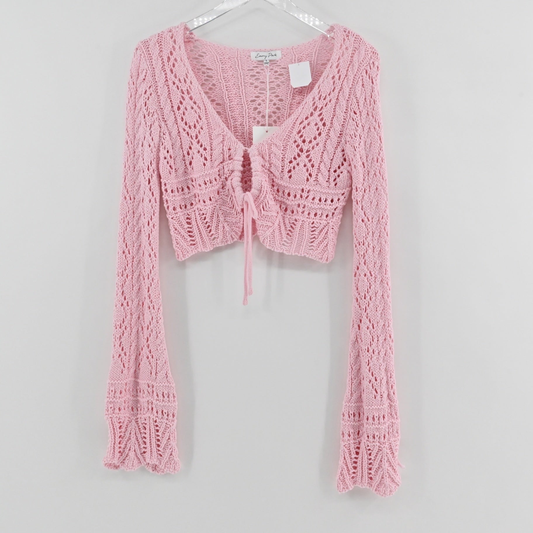 Lynn's Closet Boutique Emory Park pastel pink cropped crochet cardigan with long flared sleeves and front tie closure.