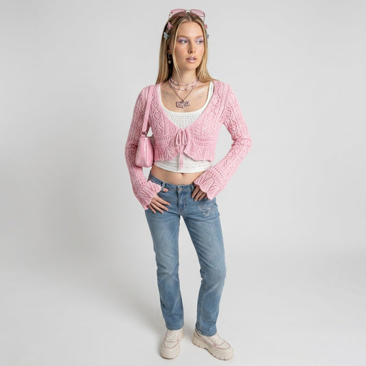 Model wearing a Lynn's Closet Boutique pink Emory Park crochet cardigan with long flared sleeves and tie-front detail.