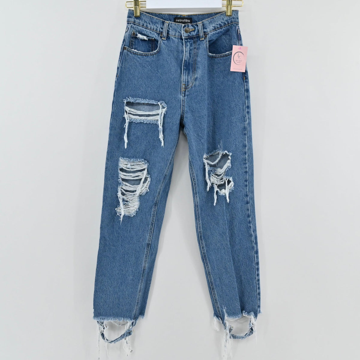 Lynn's Closet Boutique Retrofête medium-blue high-rise distressed denim jeans with frayed raw hem and knee rips.